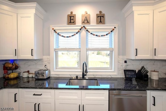 kitchen featuring stainless steel dishwasher, decorative backsplash, white cabinetry, and sink