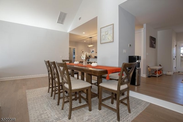 dining room featuring hardwood / wood-style flooring and lofted ceiling