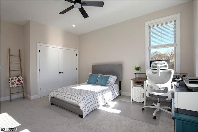 carpeted bedroom featuring ceiling fan and a closet