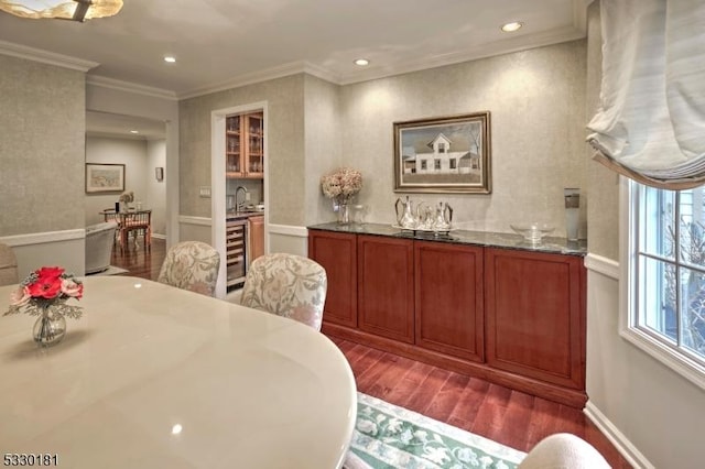 dining room with sink, dark wood-type flooring, beverage cooler, and crown molding