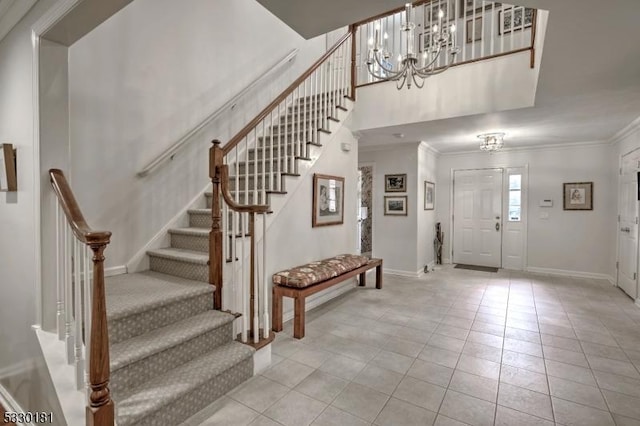 foyer featuring an inviting chandelier, light tile patterned flooring, and crown molding