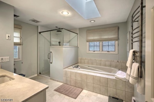 bathroom featuring a skylight, vanity, and shower with separate bathtub