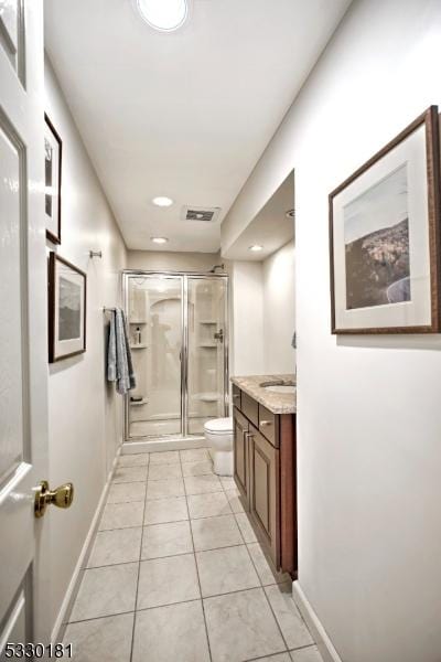 bathroom featuring vanity, tile patterned flooring, toilet, and walk in shower