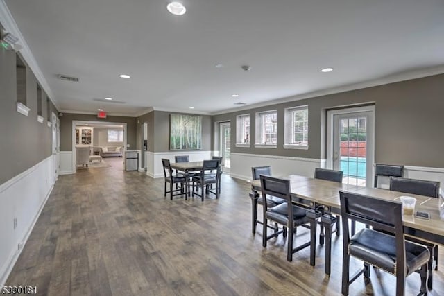 dining space with dark hardwood / wood-style flooring and crown molding