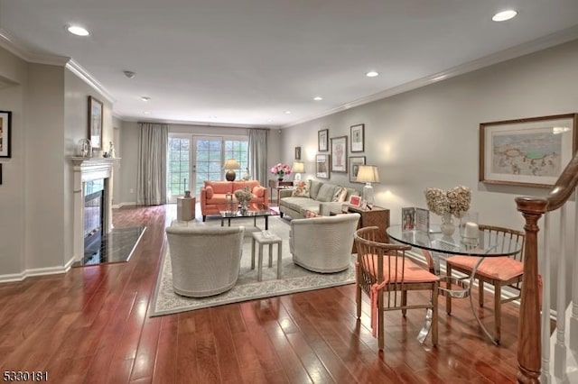 living room featuring dark wood-type flooring, a premium fireplace, and crown molding