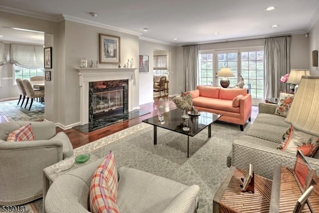 living room featuring a high end fireplace, ornamental molding, and hardwood / wood-style flooring