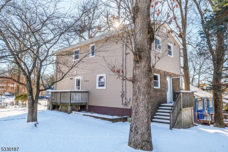 snow covered house featuring a wooden deck