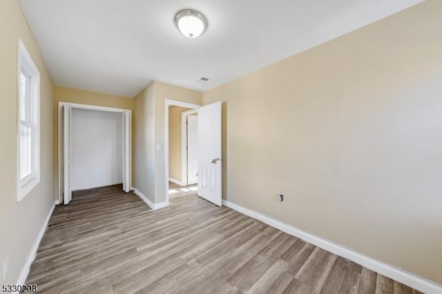 unfurnished bedroom featuring light hardwood / wood-style floors and a closet