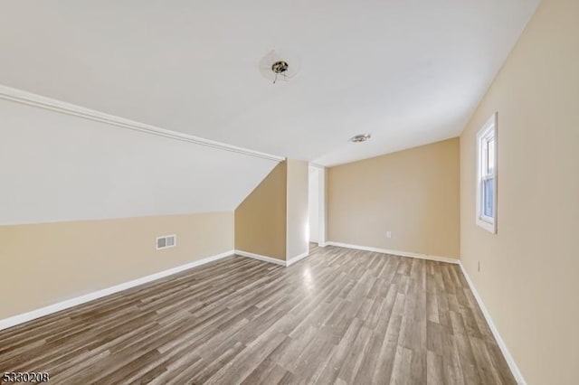 bonus room featuring light hardwood / wood-style floors and lofted ceiling