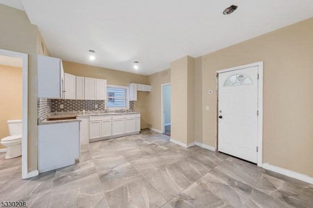 kitchen with decorative backsplash and white cabinetry