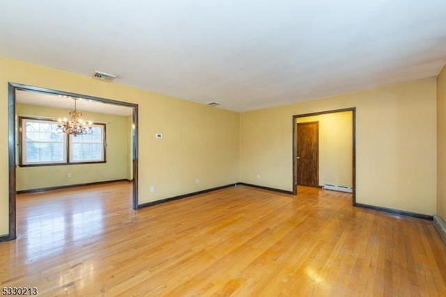 unfurnished room featuring a chandelier, a baseboard radiator, and light hardwood / wood-style floors