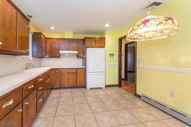 kitchen featuring sink, a baseboard radiator, white refrigerator, pendant lighting, and light tile patterned floors