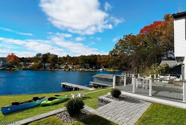 view of dock with a yard and a deck with water view