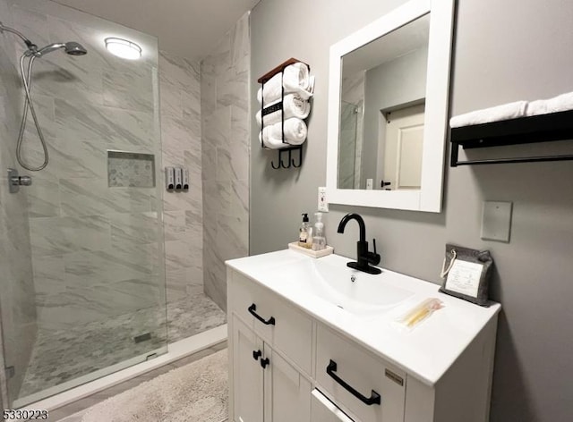 bathroom with vanity and tiled shower