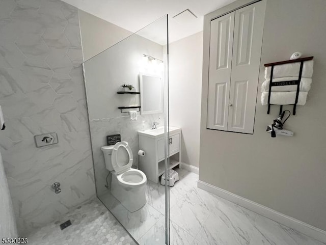 bathroom with tiled shower, vanity, and toilet