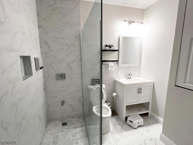 bathroom featuring tiled shower, vanity, and toilet