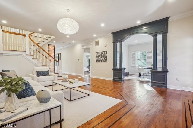 living room with dark wood-type flooring, decorative columns, and ornamental molding