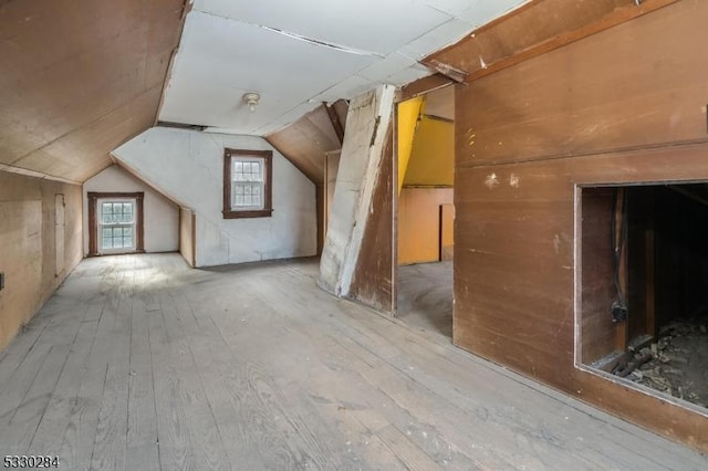 additional living space featuring hardwood / wood-style flooring and vaulted ceiling