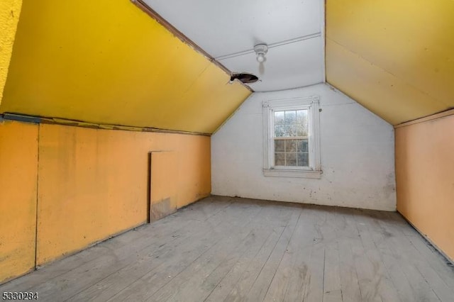 bonus room featuring lofted ceiling and light wood-type flooring