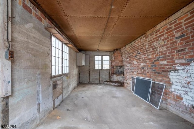 interior space with concrete flooring and brick wall