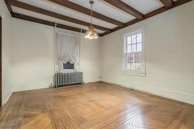 spare room with radiator heating unit, parquet floors, and beam ceiling