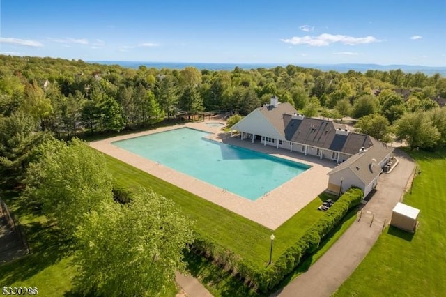 view of pool with a forest view