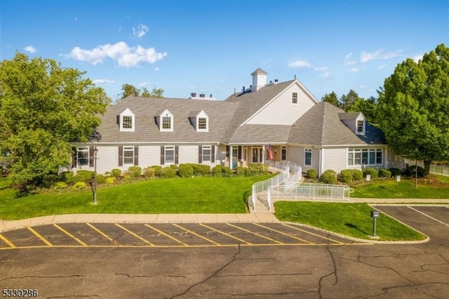 new england style home featuring a front yard