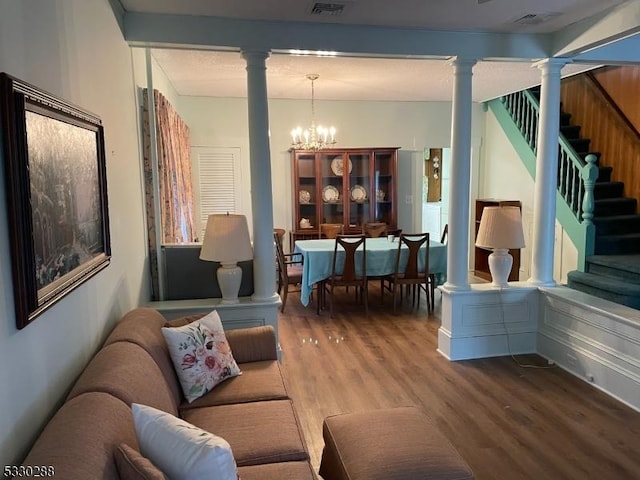 living room with washer / dryer, hardwood / wood-style flooring, beamed ceiling, and an inviting chandelier