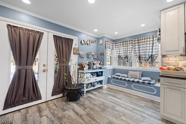 interior space featuring decorative backsplash, white cabinetry, light hardwood / wood-style flooring, and ornamental molding