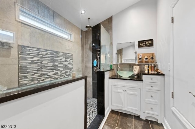 interior space with a tile shower, tile patterned floors, and vanity