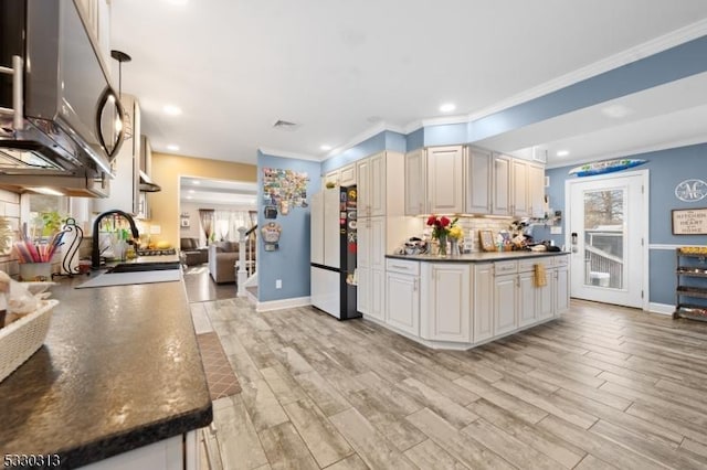 kitchen featuring backsplash, ornamental molding, sink, white refrigerator, and light hardwood / wood-style flooring