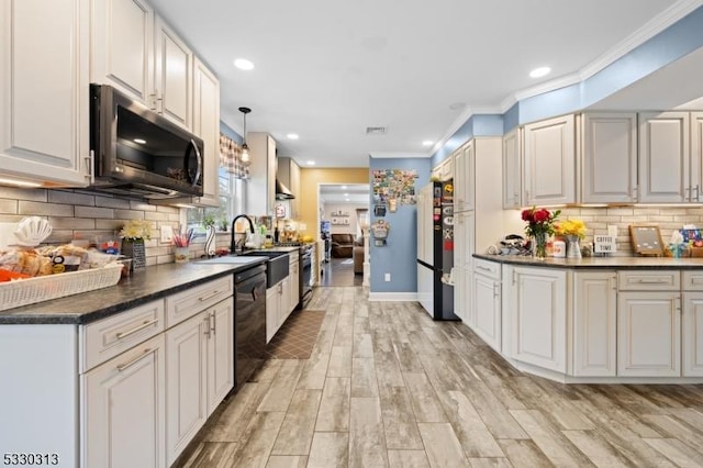 kitchen with backsplash, light hardwood / wood-style flooring, black appliances, and decorative light fixtures