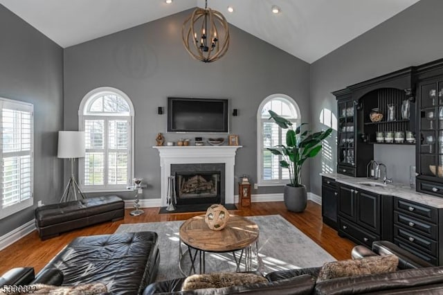 living room featuring dark wood-type flooring, high vaulted ceiling, and a healthy amount of sunlight