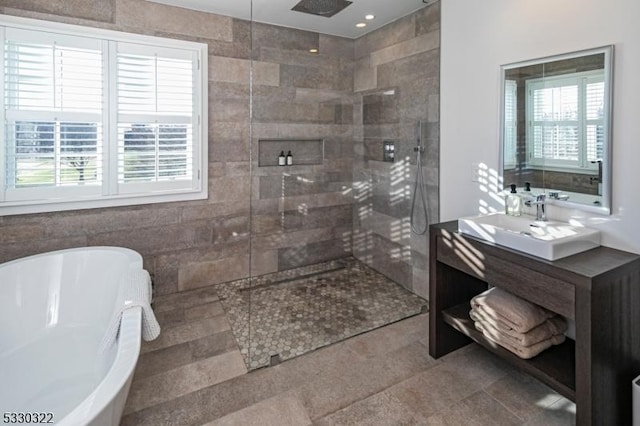 bathroom featuring separate shower and tub, tile patterned floors, vanity, and tile walls