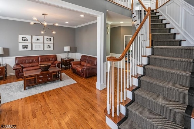 living room featuring a chandelier, crown molding, and light hardwood / wood-style floors