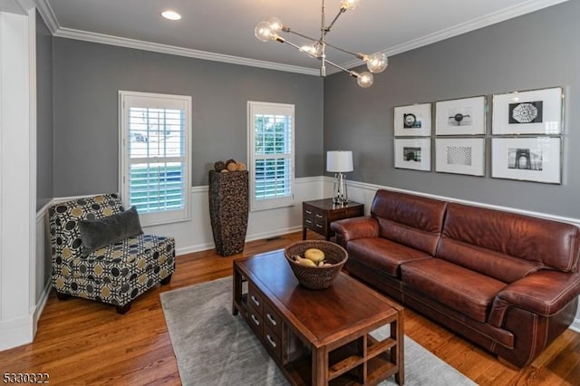 living room featuring hardwood / wood-style flooring, a notable chandelier, and ornamental molding