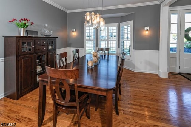 dining area featuring hardwood / wood-style floors, crown molding, and a chandelier