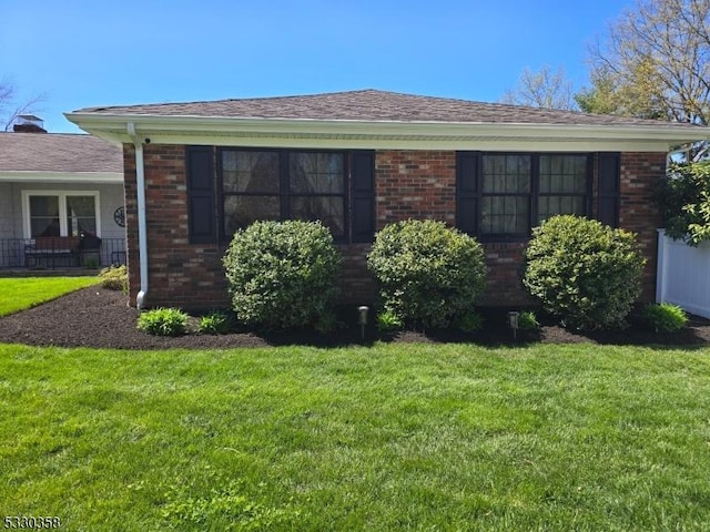 view of front of house featuring a front yard and brick siding