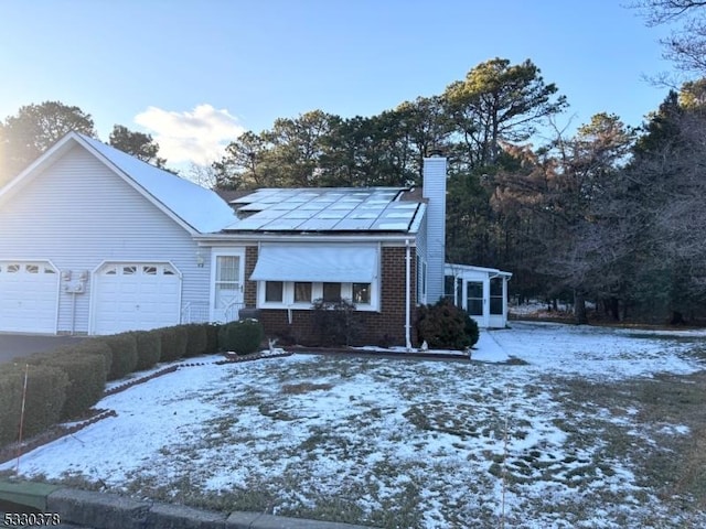 view of front of property featuring a garage and solar panels