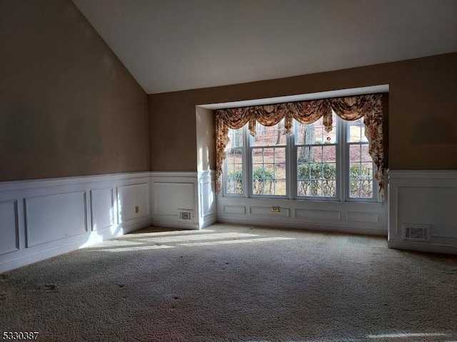 carpeted spare room featuring lofted ceiling