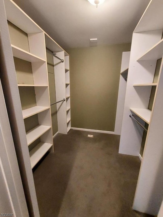 spacious closet featuring dark carpet