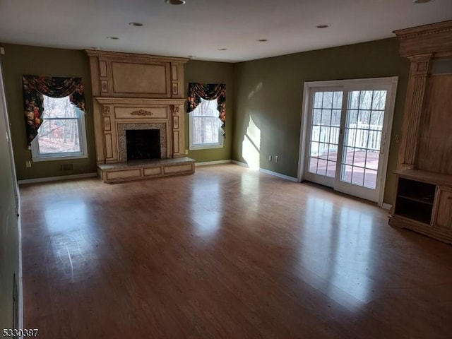 unfurnished living room featuring a fireplace and light hardwood / wood-style floors