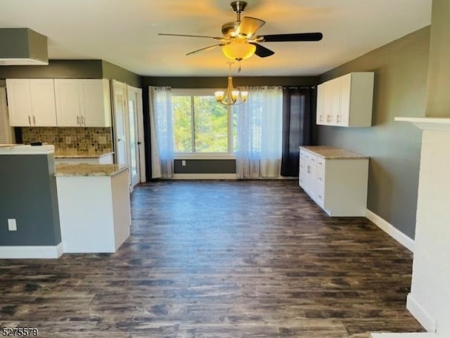 kitchen with white cabinets, ceiling fan with notable chandelier, tasteful backsplash, and dark wood-type flooring