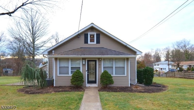 bungalow-style home featuring central AC unit and a front yard