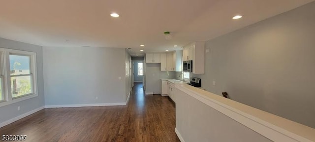 kitchen featuring dark hardwood / wood-style flooring, white cabinetry, a wealth of natural light, and range