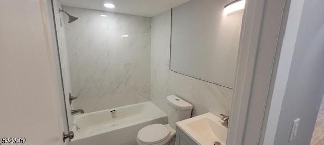 full bathroom with vanity, tiled shower / bath combo, and toilet