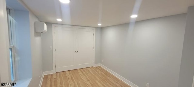 interior space featuring light wood-type flooring and a wall mounted AC