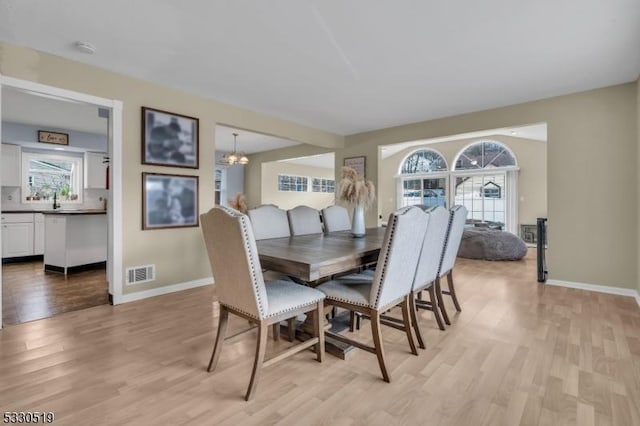 dining room featuring light hardwood / wood-style floors and a notable chandelier