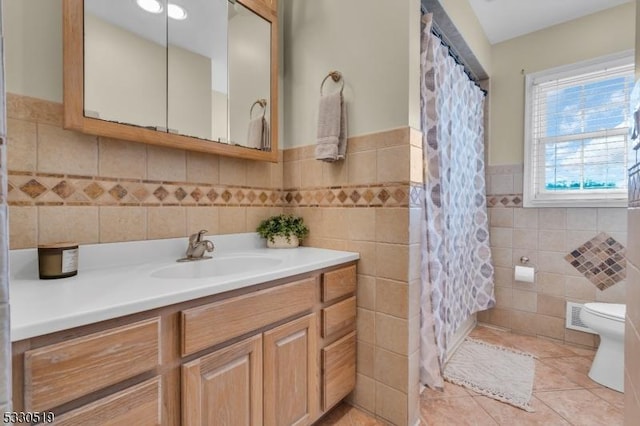 bathroom with tile walls, tile patterned flooring, toilet, and vanity