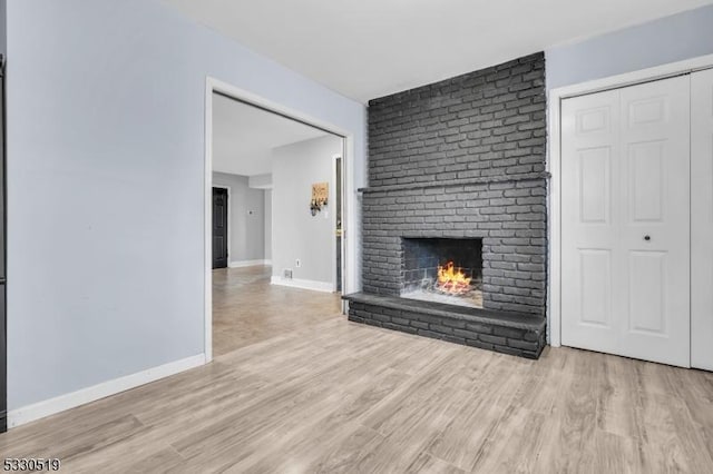 unfurnished living room featuring a fireplace and light hardwood / wood-style flooring